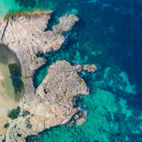 Het strand van Cala Bassa, Ibiza met helblauw water